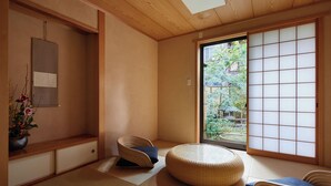 A traditional Japanese room with tatami flooring, a low wooden table, a cushioned bench, and a sliding shoji screen. - Miro Shijo Kawaramachi Tei (Kyoto)