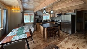 A spacious kitchen with wooden beams, a central island, and modern appliances. - 30 Mins from YNP -Trail Access-Three Little Bears (Island Park)