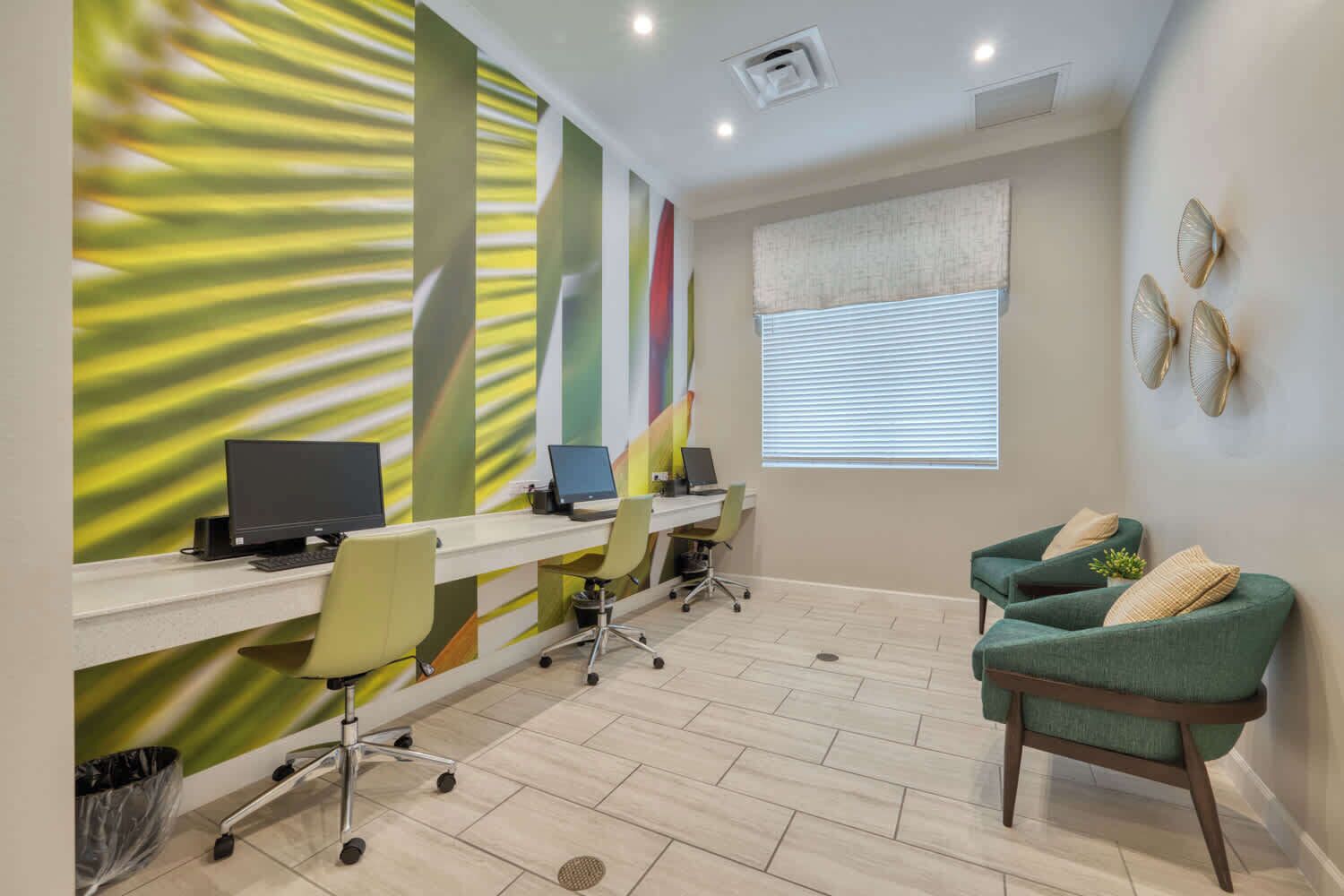 Un espacio de oficina moderno con un escritorio grande, varias sillas y un sillón verde.
