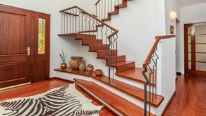 Una escalera con escalones de madera y barandillas de metal, que conduce a un piso superior.