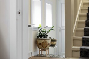 Ein Flur mit einem Blumentopf, einem Heizkörper und einer Treppe.