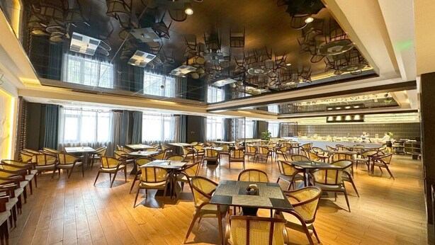 A spacious restaurant with high ceilings, multiple dining areas, and a kitchen visible in the background. - AI Lives In The Future Hotel(Xi'an Longshouyuan Daming Palace West Subway Station Branch) (Xi'an)