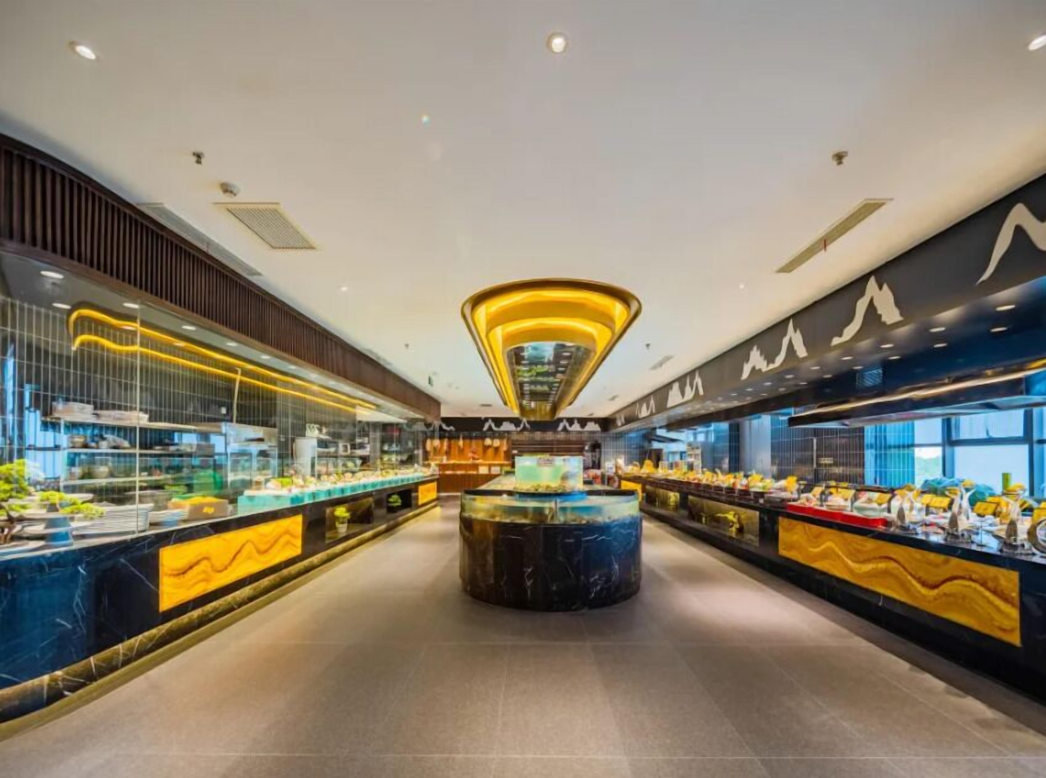 Un buffet moderne doté d’un îlot central et de plusieurs présentoirs de nourriture.