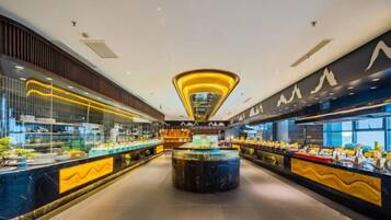 Buffet moderno com ilha central e diversas estações de comida.