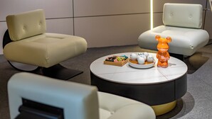 A modern living room with a round coffee table, two sofas, and a decorative bear figurine. - AI Lives In The Future Hotel(Xi'an Longshouyuan Daming Palace West Subway Station Branch) (Xi'an)