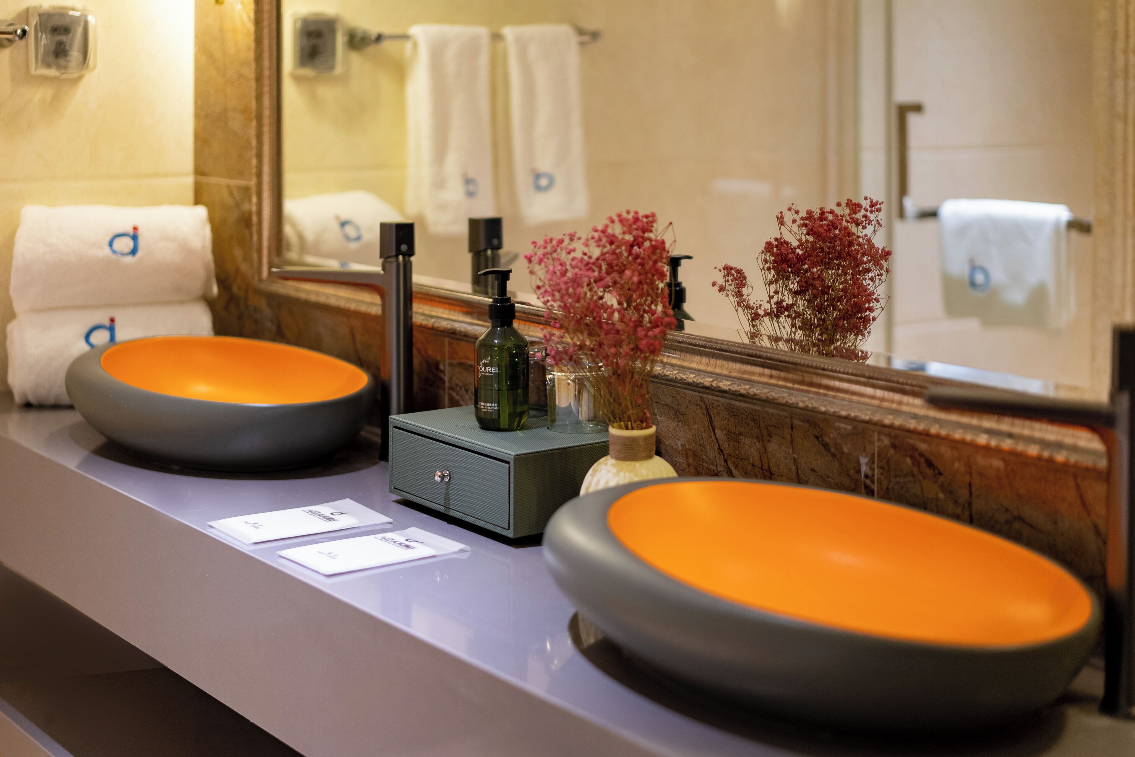 Ein Badezimmer-Waschtisch mit zwei ovalen Waschbecken, einem Spiegel und einem kleinen Schrank.