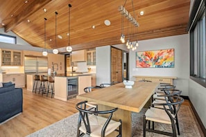 A modern kitchen with wooden cabinets, a central island, and pendant lighting.