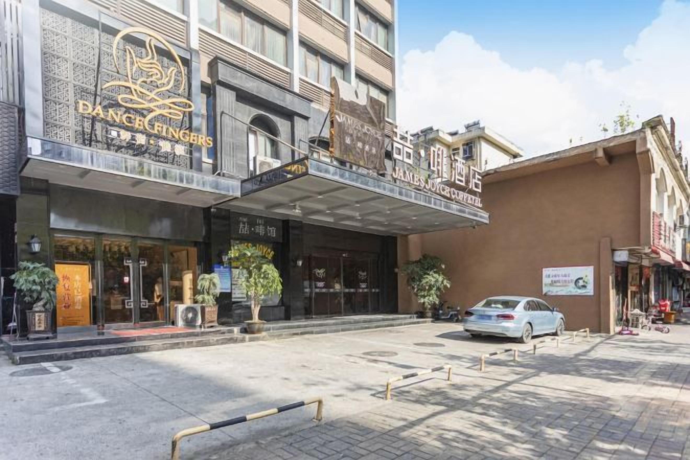 Ein Gebäude mit einem Schild, auf dem 'DANCE FINGERS' und 'JAMES JONES HOTEL' stehen.