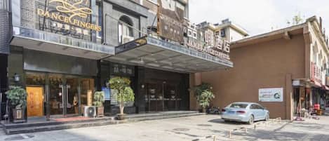 A building with a sign for 'DANCE FINGERS' and 'JAMES JONES HOTEL' on the facade.