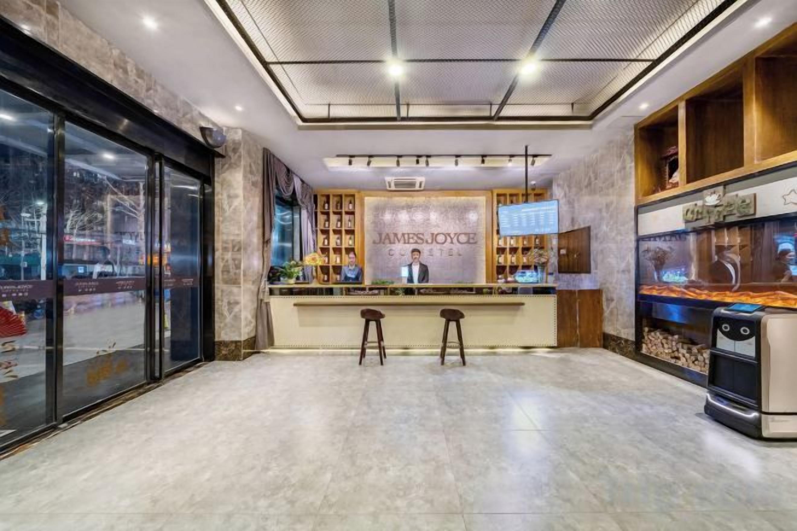 A reception area with a reception desk, two bar stools, a fish tank, and a coffee machine.