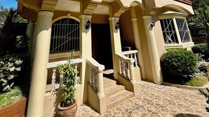 A two-story house with a balcony, columns, and a tiled entrance. - Spacious 3-bedroom house in Subic with AC, WiFi, Pool & Parking. Relax & unwind (Subic)