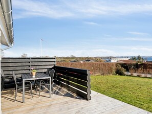 Enjoy a serene outdoor space with a deck overlooking a lush landscape and a body of water.