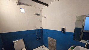Un baño pequeño con inodoro, ducha y lavamanos.