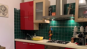 A kitchen with red cabinets, a white countertop, and a stove.