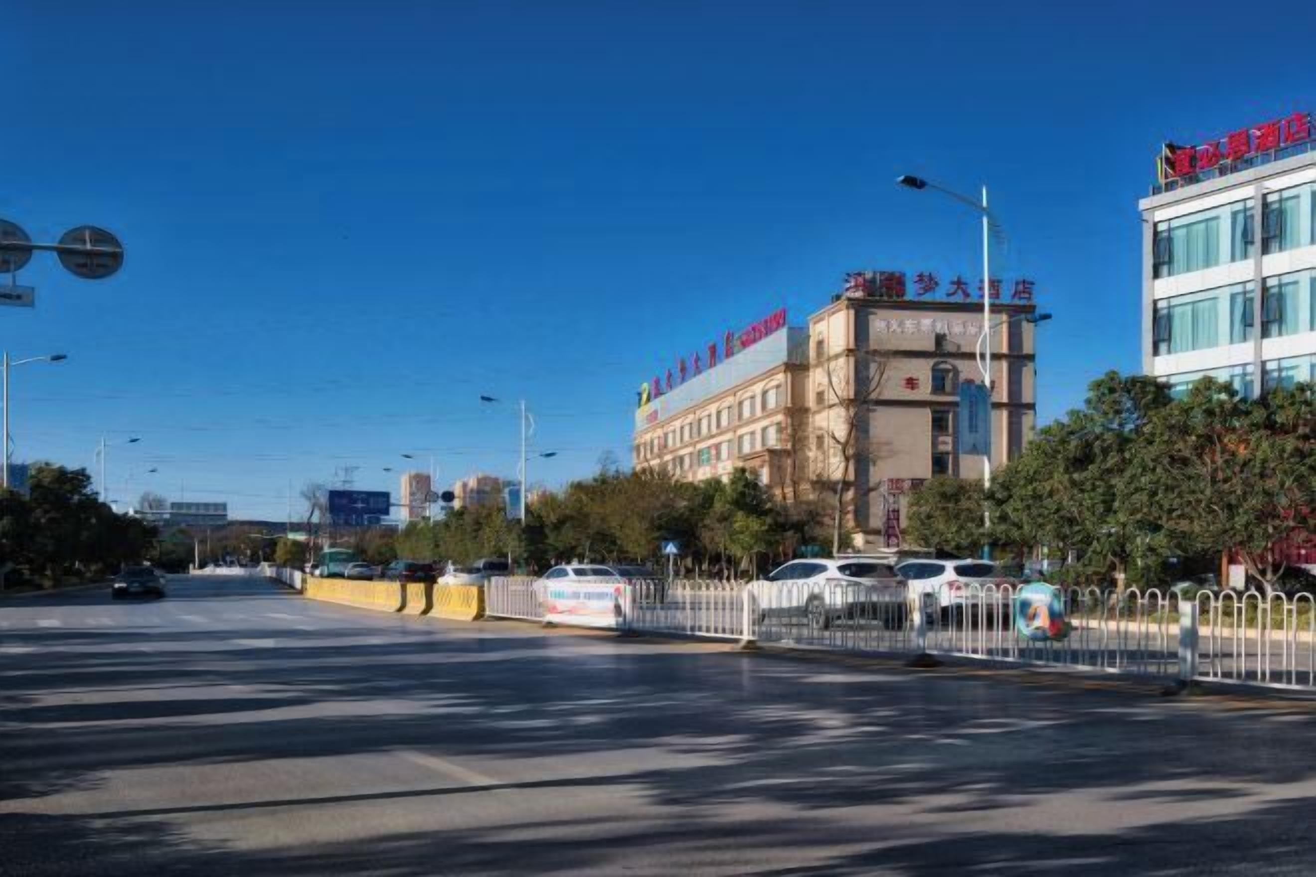 A hotel with a prominent sign, a large building with multiple floors, and a clear blue sky.