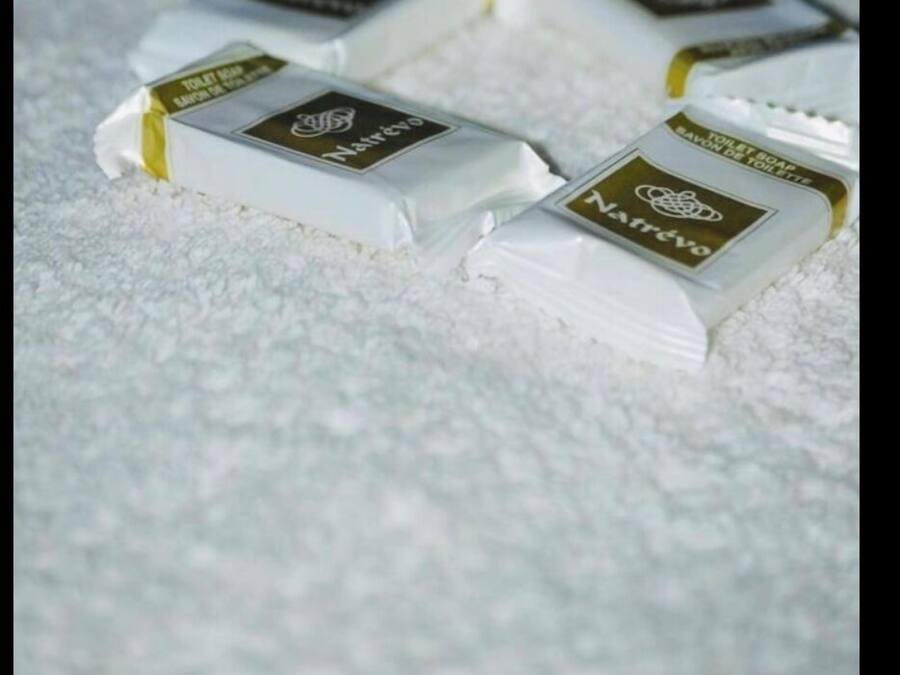 Four bars of soap on a textured surface.