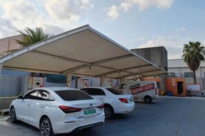 A covered parking area with two white cars parked under a shelter. - Jinjiang Star Hotel (Quanzhou Jinjiang Railway Station) (Jinjiang)