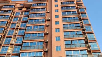 A high-rise building with multiple floors, large windows, and air conditioning units.