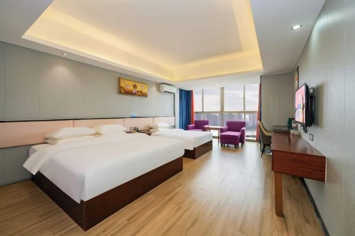 Una habitación de hotel con una cama grande, un escritorio, una silla y un televisor.