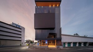 Un immeuble moderne à plusieurs étages, doté d’un toit plat, de grandes fenêtres et d’une entrée imposante.