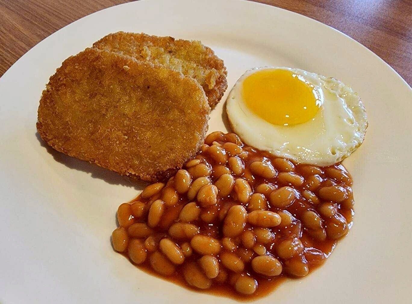 A plate with fried food, including a fried egg and baked beans.