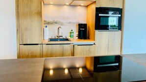 Une cuisine moderne équipée d’une cuisinière intégrée, d’une machine à café et d’un four à micro-ondes.
