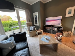Een moderne woonkamer met een bank, salontafel en een televisie.