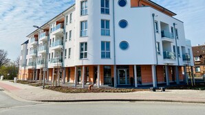 A multi-story building with balconies, a ground-level entrance, and a clear sky. - Apartment 'Duhner Allee 10, Litfaß 17' with Balcony and Wi-Fi (Cuxhaven)