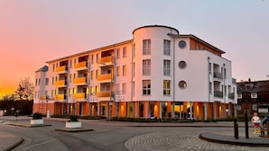 Ett hotell med flera våningar och balkonger, en rondell och en pub i bakgrunden.