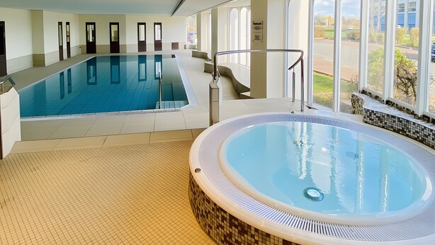 An indoor swimming pool with a hot tub, large windows, and a tiled floor. - Studio '307 Im Lord Nelson' with Sea View, Balcony and Wi-Fi (Cuxhaven)