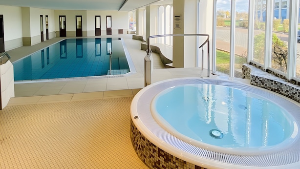 An indoor swimming pool with a hot tub, large windows, and a tiled floor. - Apartment '109' with Balcony and Wi-Fi (Cuxhaven)