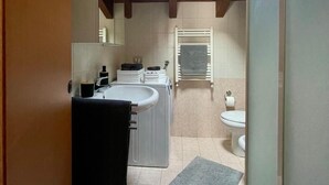 A compact bathroom with a skylight, a sink, a toilet, and a towel rack. - Attic Ancient Milan (San Giuliano Milanese)