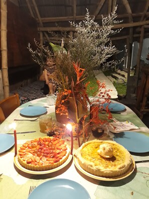 A dining table with two fruit tarts and a centerpiece.