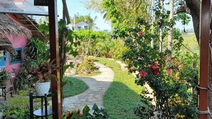 A garden pathway leading to a house with a thatched roof and potted plants. - Two independents BR in a pristine area in Hoi An (Thành phố Hội An)