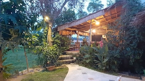 An outdoor covered seating area with a stone pathway leading to it, surrounded by lush greenery and trees. - Two independents BR in a pristine area in Hoi An (Thành phố Hội An)
