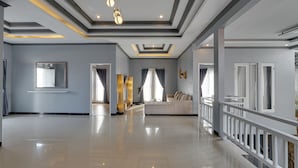 A spacious hotel lobby with a modern design, featuring a large seating area, a decorative mirror, and a well-lit ceiling with recessed lighting. - Villa Master Residance - Denpasar (Denpasar)