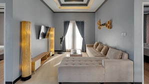 A modern living room with a sofa, TV, and a decorative wooden column. - Villa Master Residance - Denpasar (Denpasar)