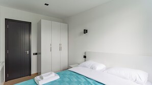 A bedroom with a bed, a wardrobe, and a door. - Apartment in historic Tbilisi (Tbilisi)