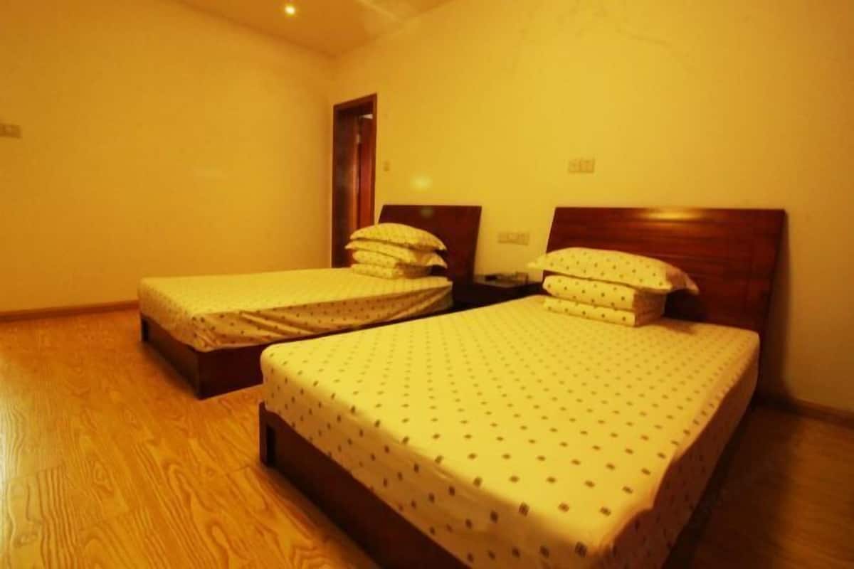 Une chambre avec deux lits simples, des têtes de lit en bois et un plancher en bois.