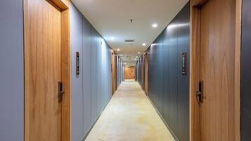 A long, narrow hallway with doors on both sides, leading to individual rooms.
