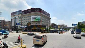 A busy urban intersection with a multi-story building featuring commercial signage.