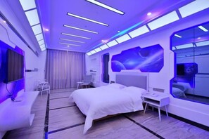 Une chambre d’hôtel moderne dotée d’un lit, d’un coin salon et d’une grande fenêtre.