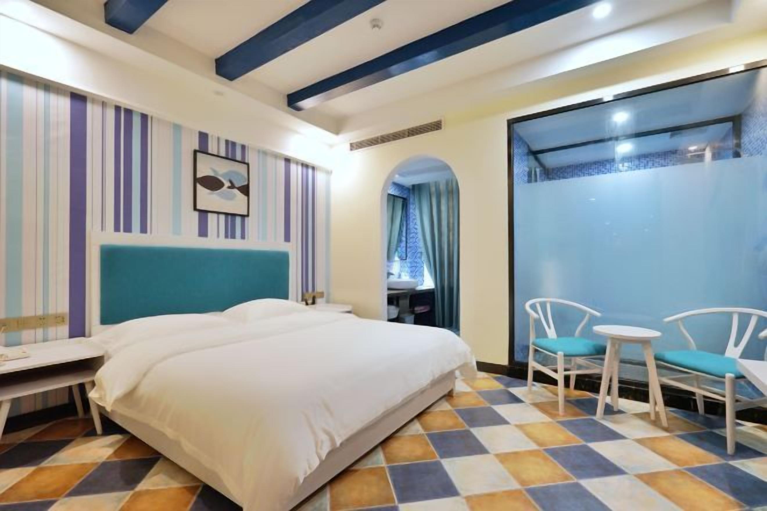 Une chambre d’hôtel avec un lit, un bureau et deux chaises.