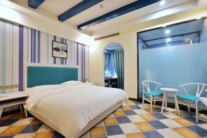 Una habitación de hotel con una cama, un escritorio y dos sillas.