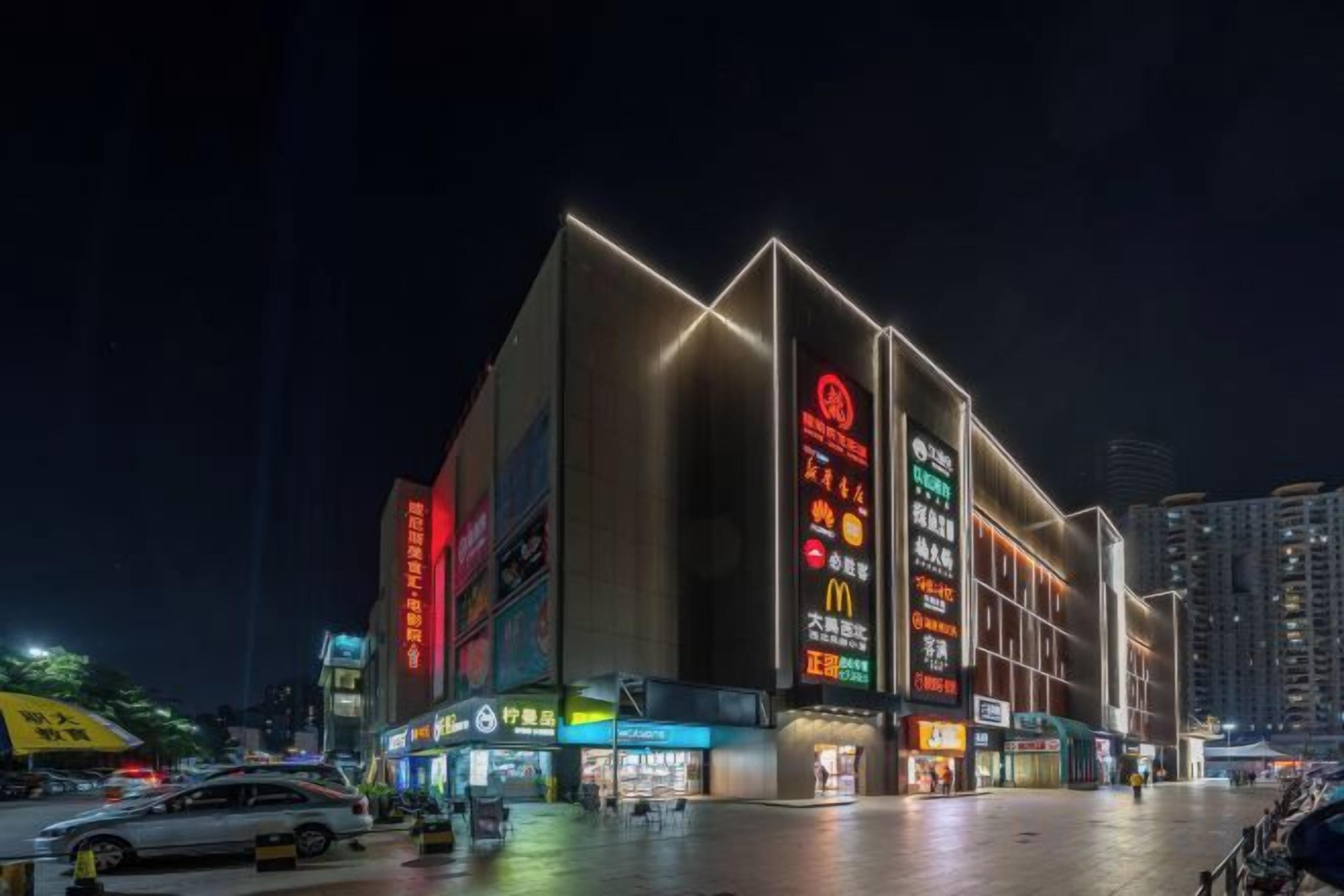 A modern building with illuminated signage and a flat roof.