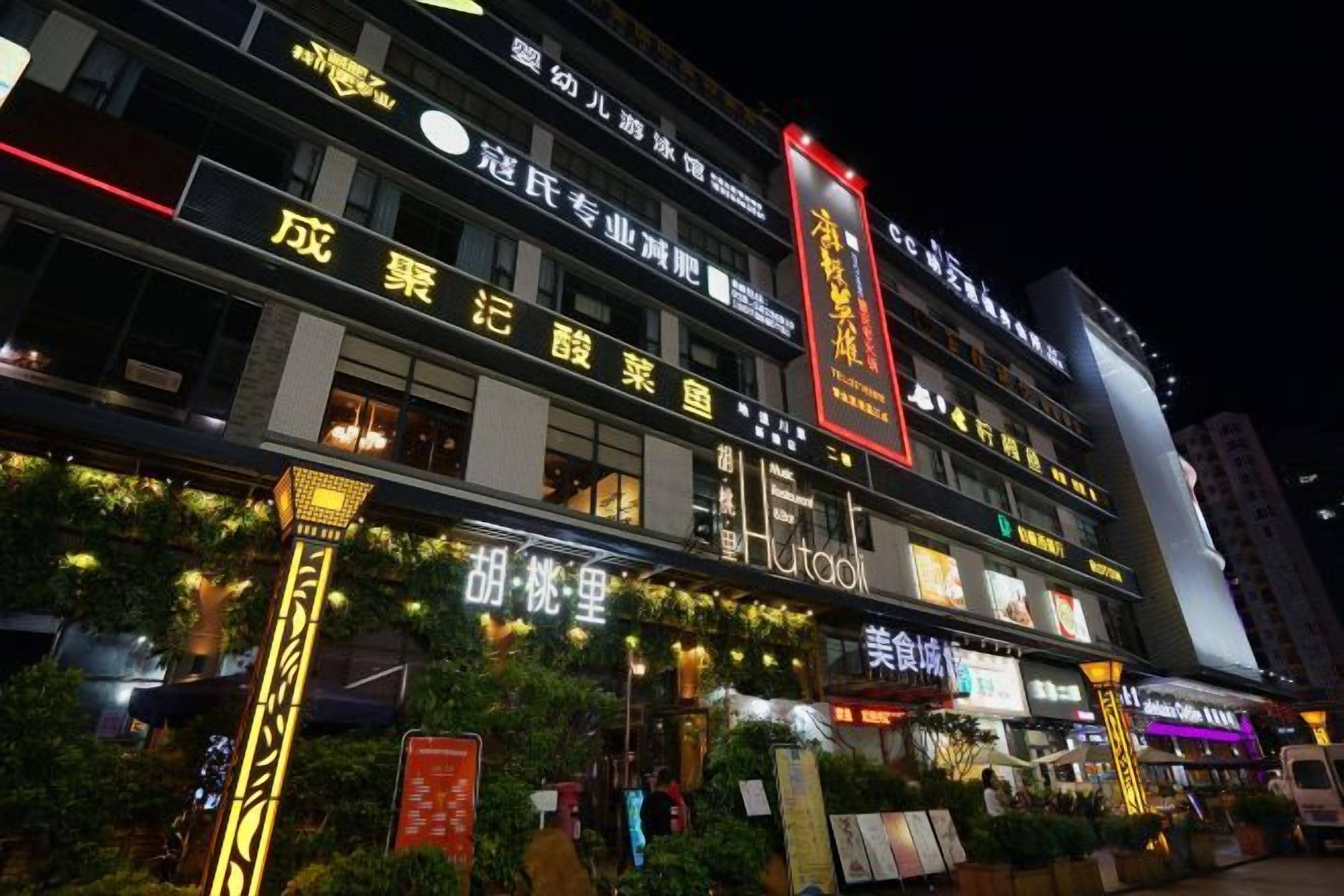 A multi-story hotel with illuminated signage and a well-lit facade.