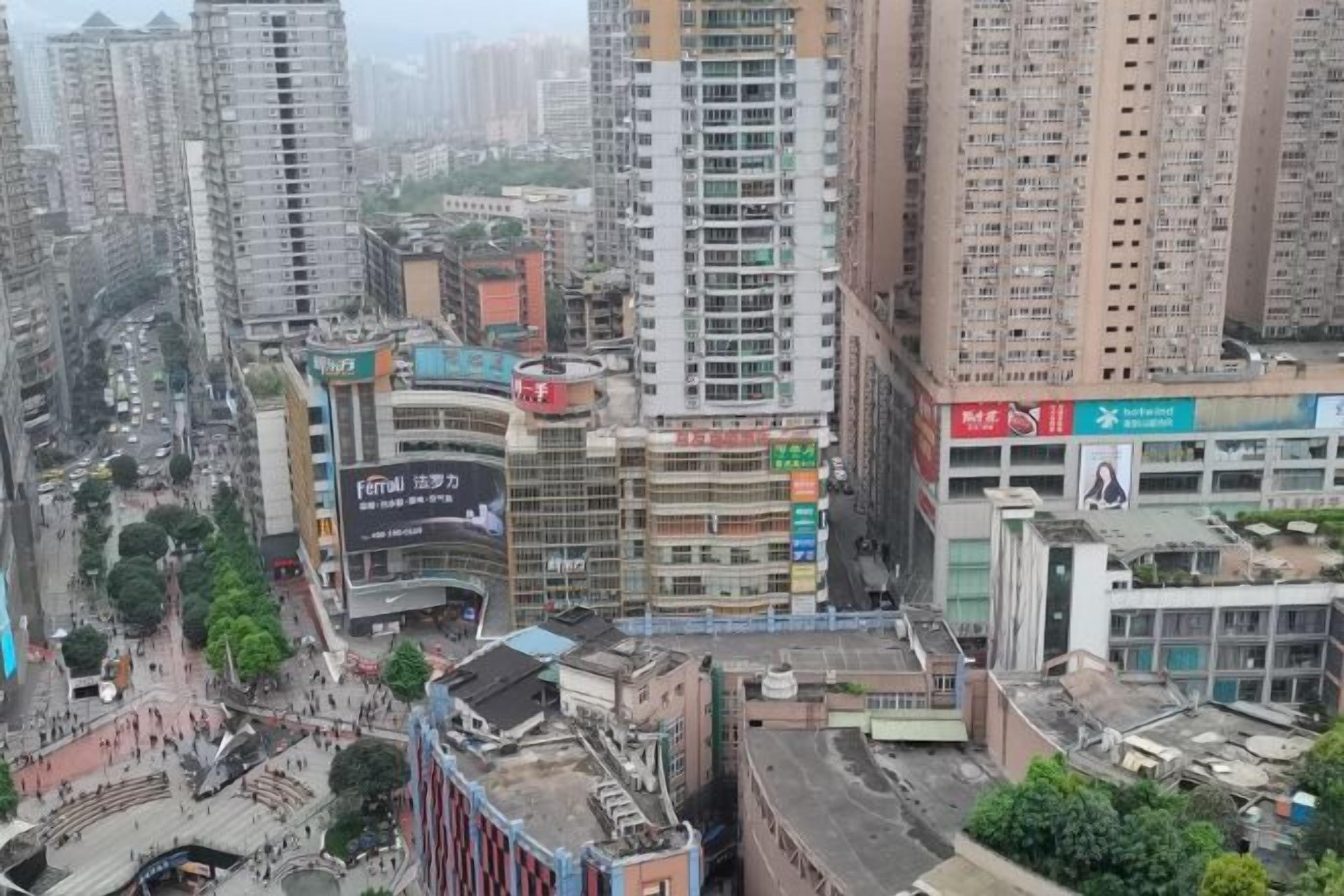 A high-rise building with multiple floors, surrounded by other tall buildings, indicating a densely populated urban area.