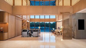 Un interior amplio y moderno con área de cocina, asientos y ventanas grandes que ofrecen vistas al exterior.
