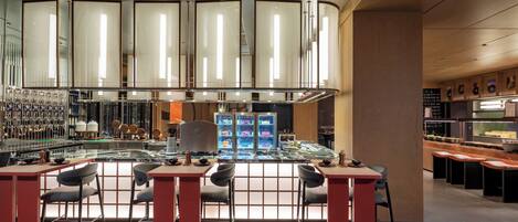 A modern bar area with a central island, seating, and a variety of bar tools and equipment.