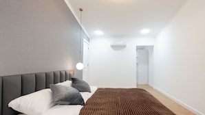 A modern bedroom with a large bed, a headboard, and a bedside table. - Chic & Modern 4BR Home in Old Tbilisi (Tbilisi)